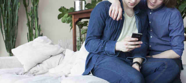 肩を組む男性二人の画像