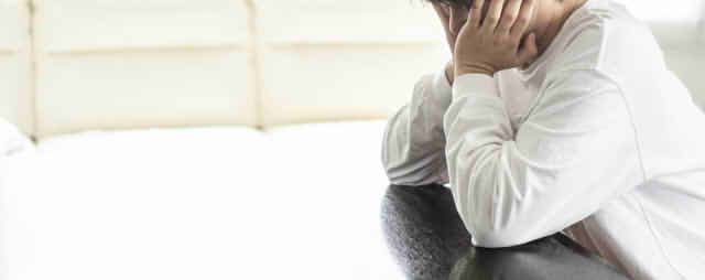 頬杖をついて思い悩む男性の画像