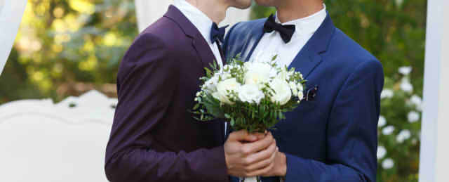 男性同士の結婚式でキスをする2人の画像