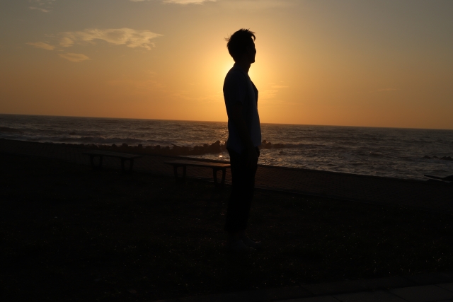 海辺にたたずむ男