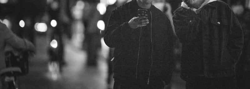 男性二人が夜の街で談笑する画像