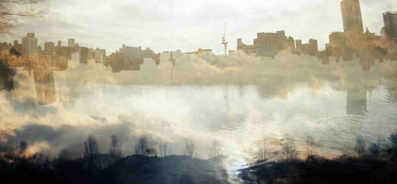 水辺に映るビル街の画像