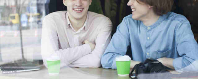 カフェで談笑する男性2人の画像