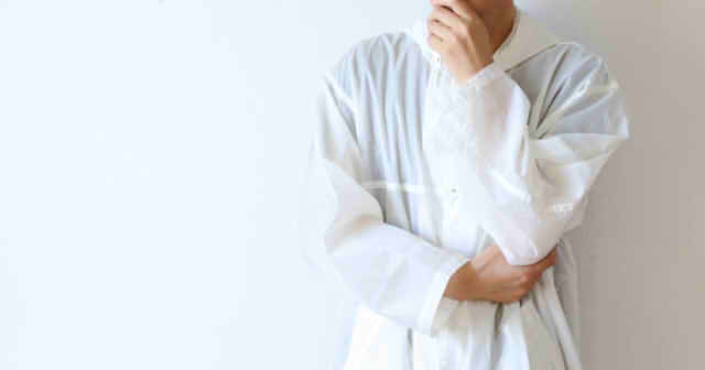 顎に手をあてて悩む男性の画像