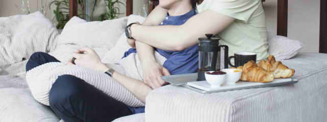 男性二人がソファでハグしている画像