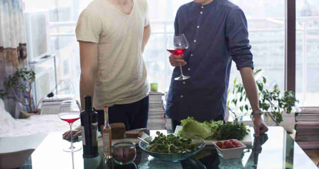 食事をする少し距離のある男性二人の画像