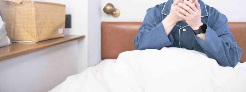 寝起きにパジャマ姿で驚く男性の画像