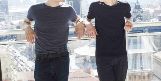 ベランダで見つめ合う男性二人の画像
