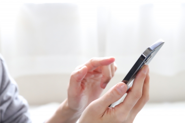 スマホを操作する手の画像