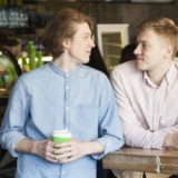 男性二人がカフェで見つめ合っている画像
