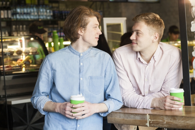 男性二人がカフェで見つめ合っている画像
