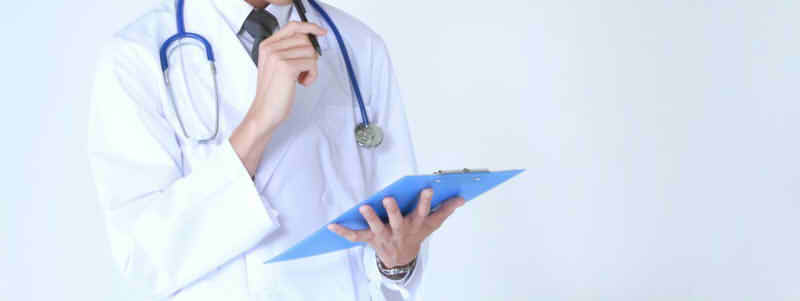 ペンを持って思い悩む男性医師の画像