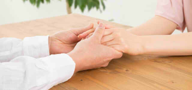 手を握り合う男女の画像