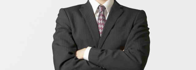 腕を組むスーツの男性画像