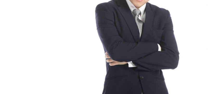 腕を組むスーツの男性の画像