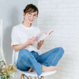 椅子で本を読む女性の画像